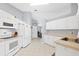 Bright kitchen featuring white cabinets, appliances, and tile flooring with neutral countertops at 5330 Alseir Rd, North Port, FL 34288