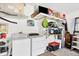 Efficient laundry room with washer, dryer, storage shelves, and good lighting for functionality at 5330 Alseir Rd, North Port, FL 34288