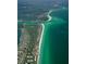 Panoramic aerial view of coastal city featuring a golf course, waterfront homes, and pristine beaches at 537 Gunwale Ln, Longboat Key, FL 34228