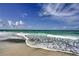 Serene beach scene with gentle waves lapping the shore, showcasing pristine sand and inviting ocean waters at 537 Gunwale Ln, Longboat Key, FL 34228