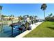 Dock featuring a boat lift perfect for watercraft enthusiasts, set against the backdrop of waterfront homes and lush greenery at 537 Gunwale Ln, Longboat Key, FL 34228