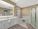 Bathroom featuring single sink vanity, a shower, and a soaking tub with arched window at 555 Park Estates Sq, Venice, FL 34293