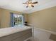 Bedroom features a window to the backyard pool, tan carpet, and blue curtains at 555 Park Estates Sq, Venice, FL 34293