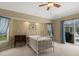 Bright bedroom with large windows, ceiling fan, and sliding glass door to outdoor views at 555 Park Estates Sq, Venice, FL 34293