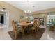 Bright dining room with wood table, seating for six, and natural light from two windows at 555 Park Estates Sq, Venice, FL 34293