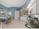 Spacious kitchen features white cabinets, granite counters, and a seamless transition to outdoor living space at 555 Park Estates Sq, Venice, FL 34293