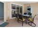 Covered patio with tile flooring and a dining table with four cushioned chairs at 555 Park Estates Sq, Venice, FL 34293