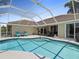Spacious screened-in pool area with patio furniture and a clear blue swimming pool at 555 Park Estates Sq, Venice, FL 34293