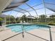 Inviting screened-in pool area with outdoor furniture and lush landscaping at 555 Park Estates Sq, Venice, FL 34293