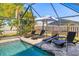 Relaxing poolside area with comfortable lounge chairs and a shaded umbrella, perfect for enjoying the Florida sun at 5704 Whistlewood Cir, Sarasota, FL 34232