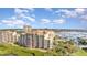 An aerial view of this condo showcases the waterfront, marina, and building's architecture at 615 Riviera Dunes Way # 208, Palmetto, FL 34221