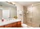 Modern bathroom featuring a wood vanity with sink, glass-enclosed shower, and contemporary fixtures at 615 Riviera Dunes Way # 208, Palmetto, FL 34221