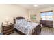Bedroom with ceiling fan, dresser, end tables, and bed with floral bedding at 615 Riviera Dunes Way # 208, Palmetto, FL 34221