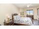 Bedroom with ceiling fan, dresser, end tables, and bed with floral bedding at 615 Riviera Dunes Way # 208, Palmetto, FL 34221