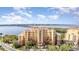 A picturesque condo complex with tropical landscaping, water views, and blue skies at 615 Riviera Dunes Way # 208, Palmetto, FL 34221