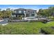 A modern home with a swimming pool, an outdoor kitchen, a patio with ample seating, and lush green landscaping at 6178 9Th Avenue Ne Cir, Bradenton, FL 34212