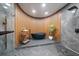 This bathroom features a modern soaking tub, pebble floor shower, wood accent wall, and sleek fixtures at 6178 9Th Avenue Ne Cir, Bradenton, FL 34212