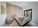 Neutral bedroom with large upholstered wall, accent chair, and a sunny window at 6178 9Th Avenue Ne Cir, Bradenton, FL 34212