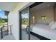 Modern bedroom with large glass door to balcony and glimpse into ensuite bathroom at 6178 9Th Avenue Ne Cir, Bradenton, FL 34212