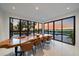 Dining room with custom wood table and wall of windows overlooking the outdoor space at 6178 9Th Avenue Ne Cir, Bradenton, FL 34212