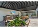 Inviting outdoor living space featuring a grill, dining area, TV, and comfortable seating under a modern pergola at 6178 9Th Avenue Ne Cir, Bradenton, FL 34212