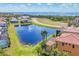 Aerial view showcasing a lakefront home with screened pool, lush landscaping, and stunning water views at 6211 Legends Blvd, Bradenton, FL 34210