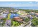 An aerial view of a stunning home near the water, featuring a pond and lush landscaping at 6211 Legends Blvd, Bradenton, FL 34210