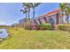 Lush backyard featuring vibrant foliage, expansive lawn, and screened lanai along waterfront for relaxed outdoor living at 6211 Legends Blvd, Bradenton, FL 34210