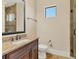 Bathroom featuring granite counters, undermount sink, a decorative mirror, and walk-in shower at 6211 Legends Blvd, Bradenton, FL 34210