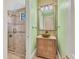 Bathroom vanity with green tile backsplash and a walk-in shower with a glass door at 6211 Legends Blvd, Bradenton, FL 34210