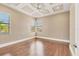 Neutral bedroom featuring a tray ceiling, hardwood floors, and several windows for natural light at 6211 Legends Blvd, Bradenton, FL 34210