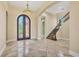 Spacious foyer with decorative tile flooring, a grand arched doorway, and an elegant staircase at 6211 Legends Blvd, Bradenton, FL 34210