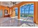 Covered patio with summer kitchen featuring a grill, overlooking an enclosed pool and seating area with beautiful ceiling fans at 6211 Legends Blvd, Bradenton, FL 34210