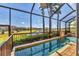 Relaxing pool area with a screened lanai and view of the lake and lush landscaping in this home's backyard at 6211 Legends Blvd, Bradenton, FL 34210