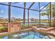 Beautiful pool with dual waterfalls and attached spa, screened in for comfortable swimming with a lake view at 6211 Legends Blvd, Bradenton, FL 34210