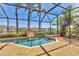 Screened pool and spa area offers relaxation with tranquil water features and a view of a serene lake with palm trees at 6211 Legends Blvd, Bradenton, FL 34210