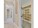 View of a walk-in closet with custom shelving and tile floors; part of a hallway and bathroom visible in the background at 6211 Legends Blvd, Bradenton, FL 34210
