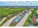 Aerial view of grand community entrance with water feature, palm trees, lush landscaping, and manicured grounds at 9487 Tequila Sunrise Dr, Sarasota, FL 34241