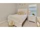 Cozy bedroom with white twin bed, plush pillows, soft decor, and natural light from the window at 9487 Tequila Sunrise Dr, Sarasota, FL 34241