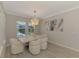 Dining area includes modern chandelier, a neutral table with chairs, and a view of the screened-in pool at 9487 Tequila Sunrise Dr, Sarasota, FL 34241