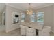 Dining area includes modern chandelier, a neutral table with chairs, and a view of the screened-in pool at 9487 Tequila Sunrise Dr, Sarasota, FL 34241