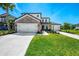 Charming two-story home with a stone facade, well-maintained lawn, and a spacious three-car garage at 9487 Tequila Sunrise Dr, Sarasota, FL 34241