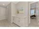 Hallway with a built-in cabinet, drawers, and artwork that leads into the office space at 9487 Tequila Sunrise Dr, Sarasota, FL 34241