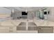 A white farmhouse sink on the large island opens to the living room with sliding glass doors at 9487 Tequila Sunrise Dr, Sarasota, FL 34241