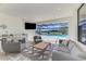 The lanai area includes a grill, sink, TV, and comfortable seating overlooking the pool at 9487 Tequila Sunrise Dr, Sarasota, FL 34241