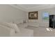 Bright living room with white sectional sofa, decorative pillows, and a stylish aviation-themed artwork at 9487 Tequila Sunrise Dr, Sarasota, FL 34241