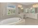 Spacious Main Bathroom includes a large tub and dual vanity sinks below a large window at 9487 Tequila Sunrise Dr, Sarasota, FL 34241