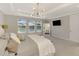 Bright main bedroom boasts a pool view, tray ceiling, statement lighting, and a full length mirror at 9487 Tequila Sunrise Dr, Sarasota, FL 34241