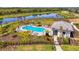 Aerial view of community pool with ample seating, lush landscaping, cabana, and views of the lake at 9487 Tequila Sunrise Dr, Sarasota, FL 34241