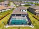 Aerial view of a screened pool with hot tub, set in a well-manicured backyard, with houses in the distance at 9487 Tequila Sunrise Dr, Sarasota, FL 34241